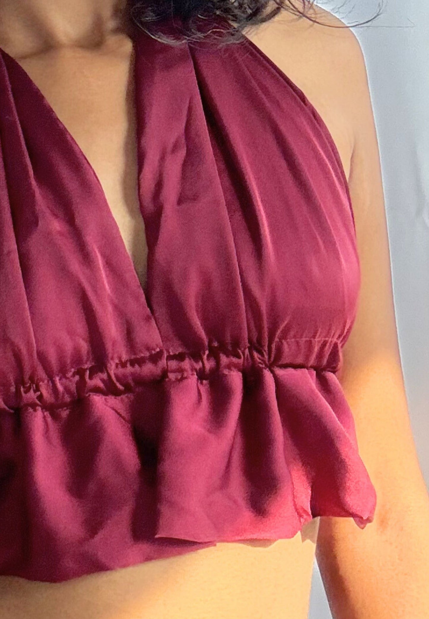 Close-up of a burgundy halter top worn by a person.